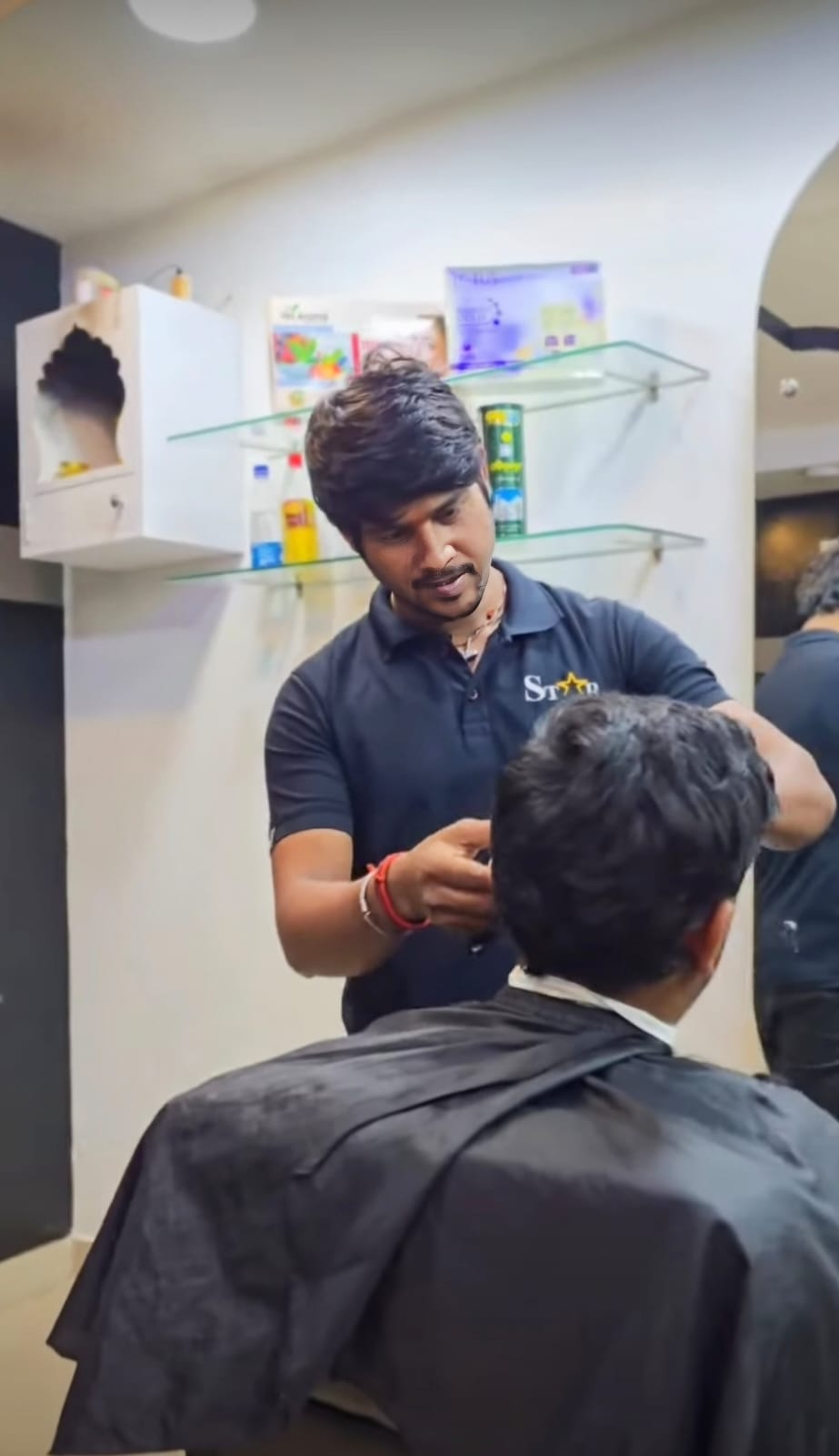 Barber styling a client's hair at STAR Men's Professional Salon