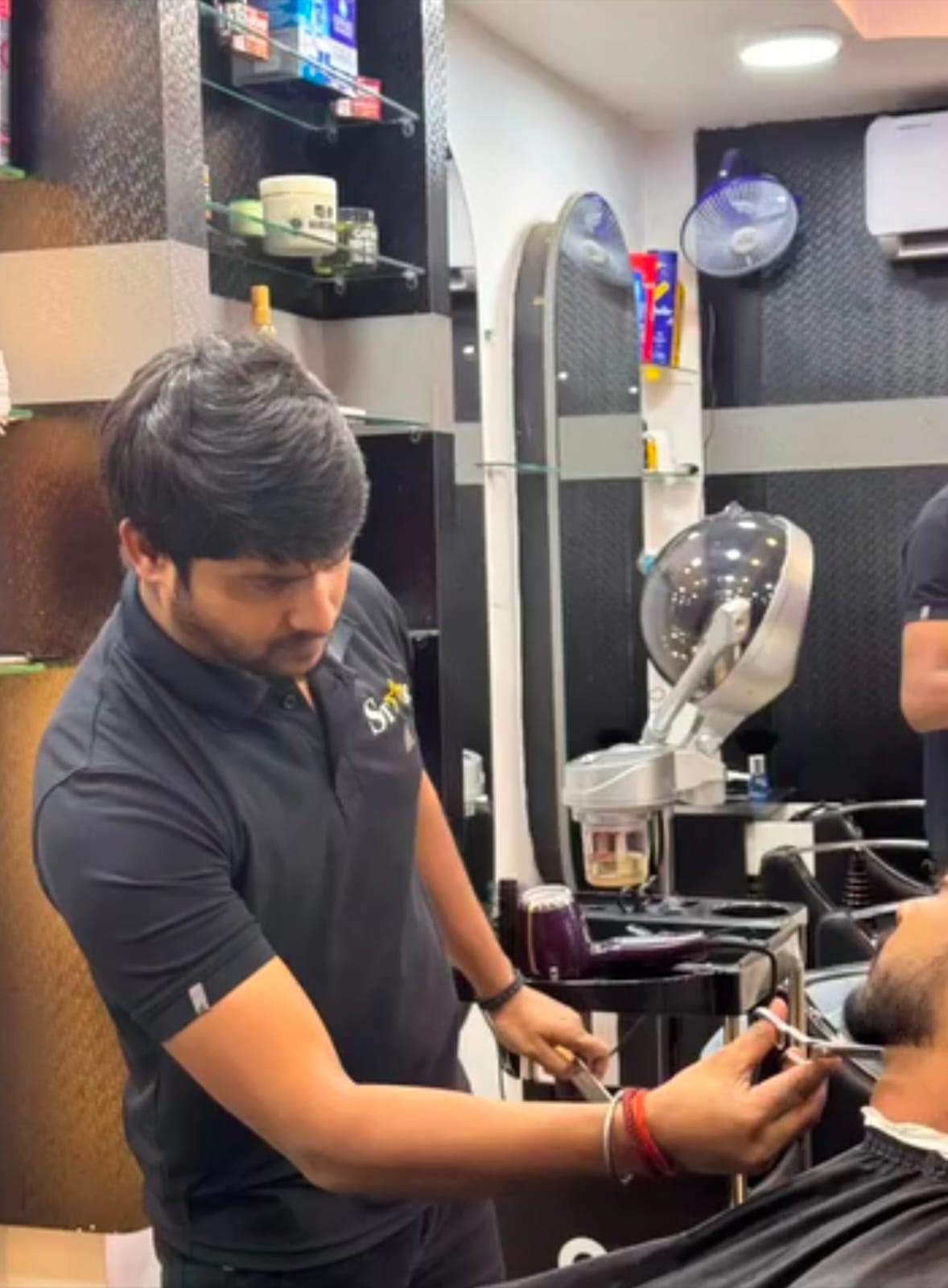 Barber giving a beard trim at STAR Men's Professional Salon